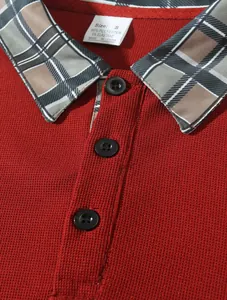 Detailansicht des karierten Reverskragens und der Knöpfe an einem roten Herren-Poloshirt