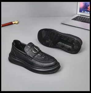 Macro view of black leather loafers featuring unique texture and refined metal buckle detail