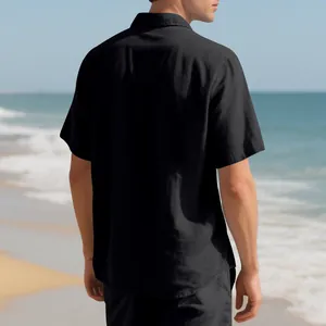 Rear view of a men's black short-sleeved linen shirt on a sunny beach background