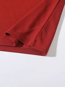 Nahaufnahme des roten Strickstoffs und des doppelt genähten Saums dieses Herren-Poloshirts.
