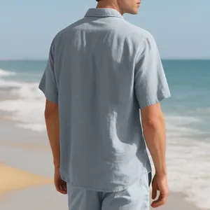 Back view of a men's light blue casual woven shirt set on a sunny beach