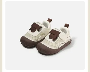 Gros plan de chaussures de marche respirantes pour tout-petits en maille beige et marron