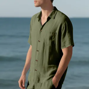 Side detail of men's olive green casual woven shirt with pocket in seaside setting