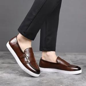 Gros plan de baskets élégantes en cuir marron avec double boucle portées avec un pantalon