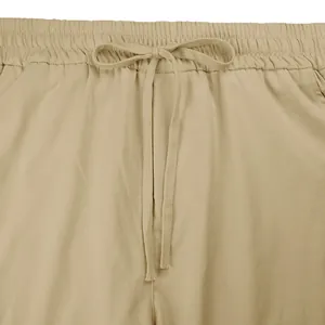 Dettaglio dell'elastico in vita con coulisse regolabile su pantaloni cargo color kaki.