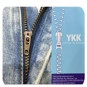 Detailed close-up showing high-quality YKK metal zipper on men's blue denim jeans