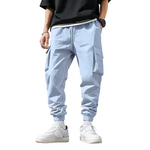 Dettaglio di pantaloni cargo celesti da uomo con multitasche e polsini su sfondo bianco