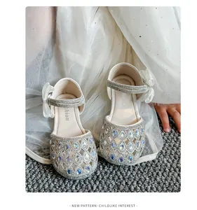 Dettaglio di scarpe da principessa bianche per bambina con strass e design traforato.