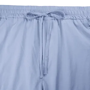 Dettaglio macro della fascia elastica in vita e della coulisse sui pantaloni cargo azzurri