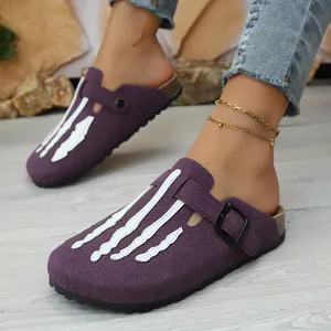 Detailed view of purple suede clogs with white skeleton bone applique and black buckle.