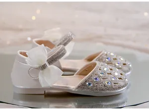 Dettaglio di sandali da principessa per bambine con strass scintillanti e un fiocco
