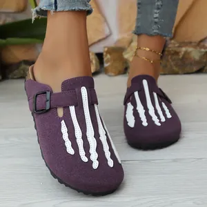 Purple suede clogs featuring white skeleton hand design on feet for a detail view.