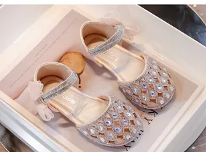 Primo piano di sandali rosa da principessa per bambina con strass, fiocco e design traforato