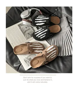 Detailed shot of suede clogs with white skeleton hand print in black and brown colors