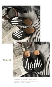 Detailed view of black suede clogs with white skeletal hand bone pattern design.