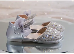 Primo piano di scarpe da principessa argento per bambine con strass e fiocco