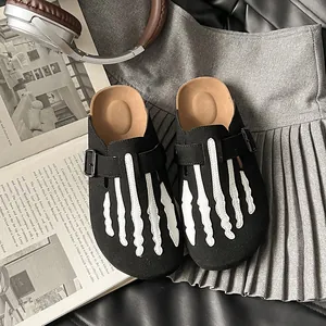 Black suede platform clogs for women featuring a white skeleton hand design on top