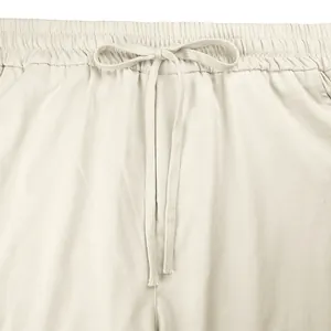 Vista dettagliata della vita elastica regolabile e della coulisse sui pantaloni cargo beige.