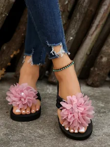 Detailed view of stylish women's thick-soled flip-flops with a large pink flower
