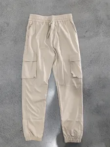 Vista completa dei pantaloni cargo beige da uomo con tasche multiple e coulisse.