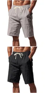 Close-up view of grey and black men's linen shorts with vertical white stripes and drawstring