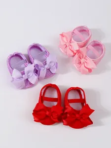 Detailansicht von farbenfrohen Baby Mädchen Lauflernschuhen mit großen dekorativen Schleifen.