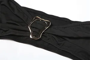 Detailansicht der silbernen Metallschnalle an einem sexy schwarzen trägerlosen Jumpsuit