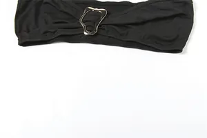 Nahaufnahme der unregelmäßigen silbernen Metallschnalle am schwarzen Bandeau-Oberteil des Jumpsuits