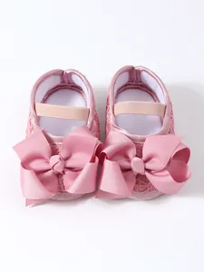 Detailansicht von rosa Babyschuhen für Mädchen mit großen dekorativen Schleifen