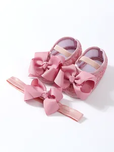 Detailansicht der rosa Baby-Mädchen-Spitzenschuhe mit passendem Schleifen-Stirnband