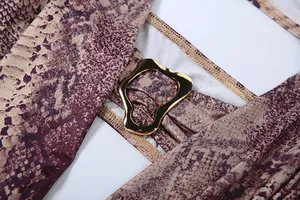Detailansicht eines sexy Overalls mit Schlangenprint und goldener Metallschnalle
