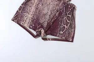 Detaillierte Makroansicht der Stoffstruktur und des Schlangendrucks auf einem Damen Sommeroutfit