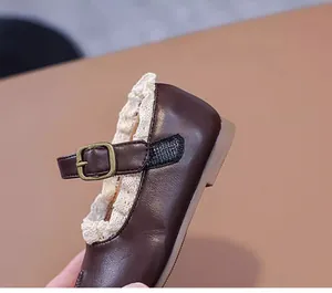 Detailansicht brauner Baby-Mary-Jane-Schuh mit zarter Spitze und Schnallenverschluss.