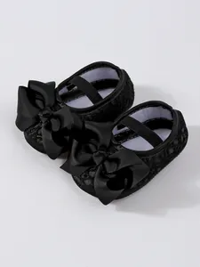 Detailansicht der schwarzen Baby-Mädchen-Schuhe aus Mesh mit großen Satinschleifen