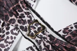 Nahaufnahme des Jumpsuits mit Leopardenmuster, goldener Metallschnalle und Nähten.