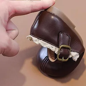 Flexibles weiches Sohlendetail von braunen Baby-Prinzessinenschuhen aus Leder mit Spitze.