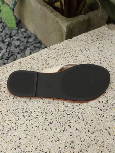 Detailweergave van de antislip zwarte zool van platte teenslippers voor dames