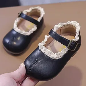 Detailaufnahme schwarzer Baby-Mary-Janes für Mädchen mit weißem Spitzenbesatz