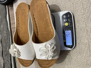 Detail showing the lightweight design of white floral wedge slippers weighing 192g