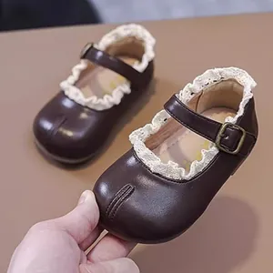 Detailansicht von dunkelbraunen Baby-Mädchen Mary Jane Schuhen mit eleganter Spitze