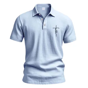 Macro detail of men's light blue linen polo shirt with a faith cross design on chest