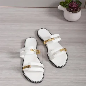 Sandales plates blanches élégantes avec accents métalliques dorés et bord de semelle à motifs