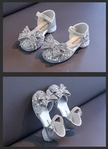 Close-up of girls silver princess sandals with sparkling rhinestone bow and sequins