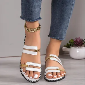 Sandales plates blanches pour femmes avec boucles en métal doré et semelle cloutée