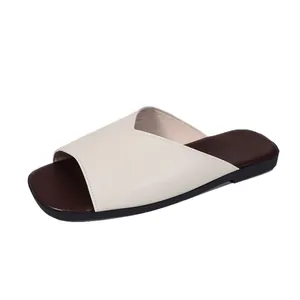 Close-up of French style V-cut leather flat slippers with square toe and two-tone design.