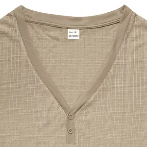 Detail shot of men's beige Henley shirt featuring a textured breathable knit fabric.