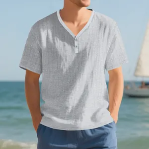 Detail of a men's grey textured slub Henley shirt presented in a summer coastal lifestyle setting.