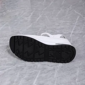 Close-up detail of white wedge sandals featuring non-slip black thick rubber outsole