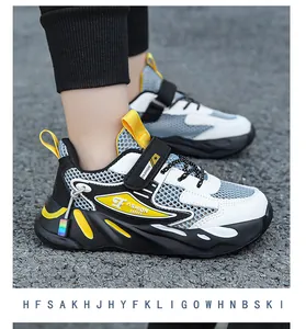Dettaglio scarpe da basket per ragazzo in bianco, nero e giallo con inserti mesh.