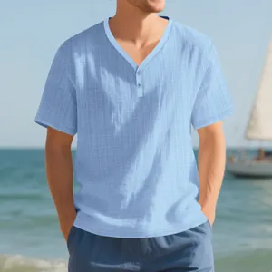 Close-up detail of light blue slub linen-textured men's Henley shirt in beach setting
